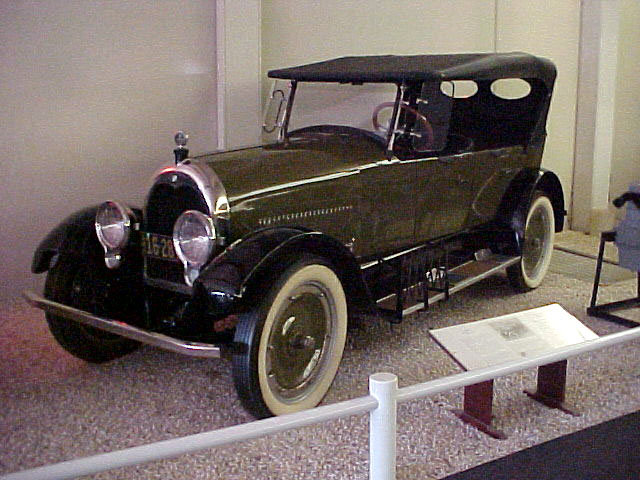 Green car on display at a museum