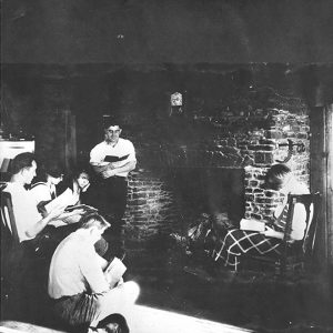 White students reading in room with fireplace