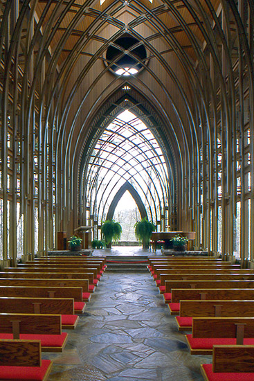 Interior of chapel sanctuary with pews and arched roof supports