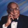 Older African-American man with glass in suit and bow tie