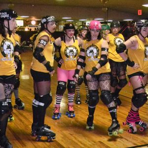 Young white women in yellow shirts helmets and roller skates