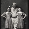 Portrait white male soldier with arms around two shorter white women matching polka dot dresses