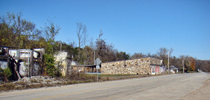 Single-story stone storefront building on rural road