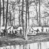 Men and tents with trees and hanging laundry