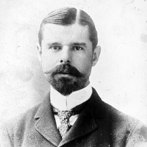 White man with beard and mustache in suit and tie
