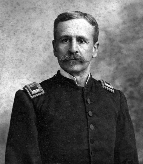 White man with mustache standing in military uniform