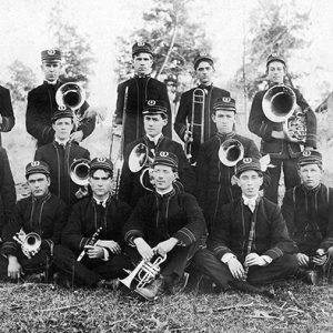 Group of young white men in uniform with brass instruments and "Fordyce concert band" drum