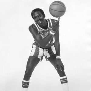 African-American man in basketball jersey uniform spinning a basketball on one finger