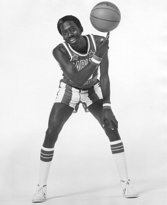 African-American man in basketball jersey uniform spinning a basketball on one finger