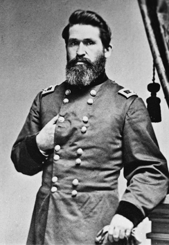white man with beard poses with one hand inside military jacket