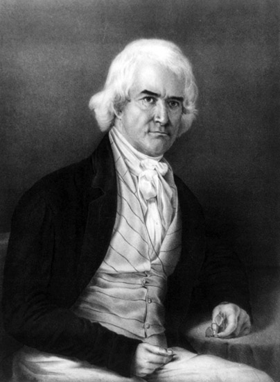 Portrait white man seated stern expression bushy white hair dark eyebrows suit cravat striped vest