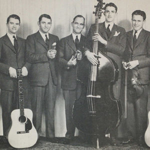 Group of white men in suits posing with musical instruments