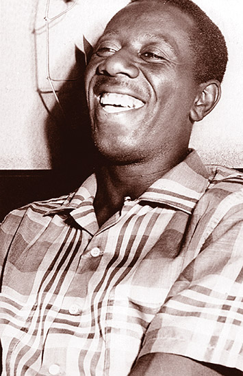 African-American man laughing in plaid shirt