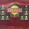 Wall of portrait text plaques with central round sign "Arkansas Business Hall of Fame"