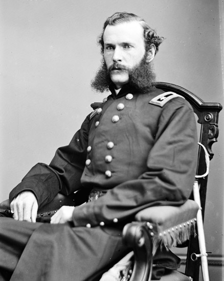 white man with mutton chops in military regalia sitting in chair