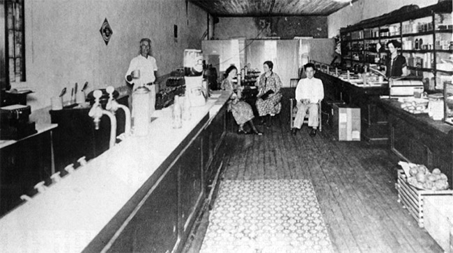 Two white men and three white women in cafe with shelves and bar
