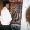 Hindu man in collared shirt slacks praying to shrine in closet with  strand lights incense