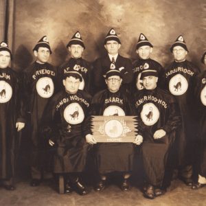 Group of white men in matching black robes and pointed hats