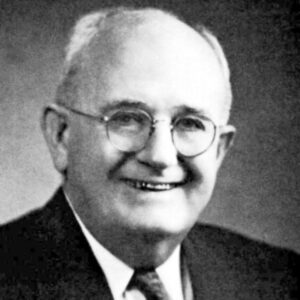 older white man in glasses and suit