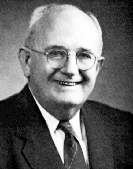older white man in glasses and suit