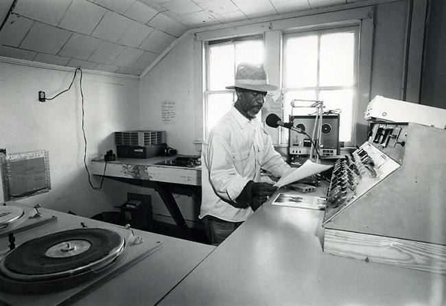 African-American man with hat working in radio station