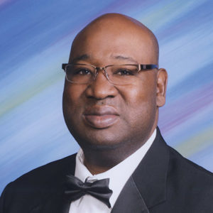Bald African-American man with glasses in suit and tie