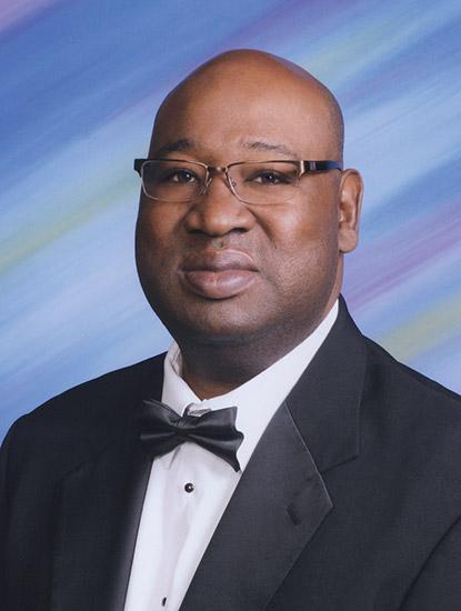 Bald African-American man with glasses in suit and tie