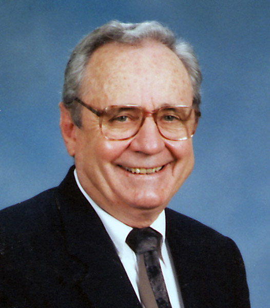 Portrait elderly white man smiling with short hair glasses suit and tie