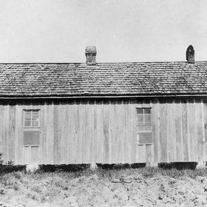 Side view of single-story house with covered porch on grass