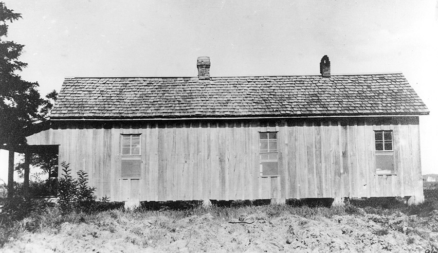 Side view of single-story house with covered porch on grass