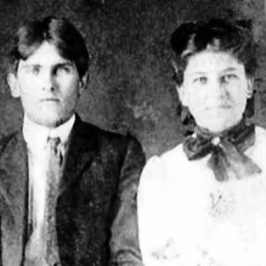 Young white man in suit and tie and young woman in dress with bow tie