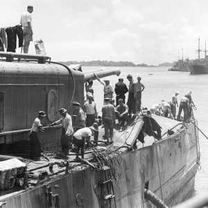 White sailors and officers on damaged ship deck at sea