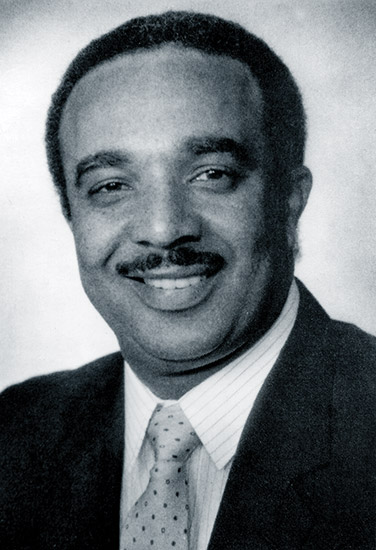 African-American man with mustache in suit and tie
