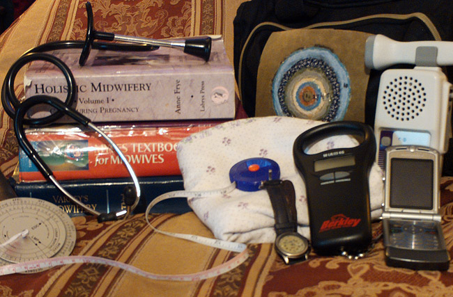 Stack of books with medical equipment face mask watch and flip cell phone on chair with floral pattern