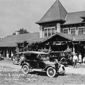 Panorama of people on horseback and cars in front of  estate hand-labeled "club house"