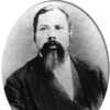 African-American man with long beard in suit in oval frame