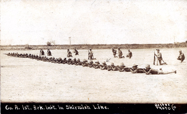 Long row prone soldiers in dirt field aiming rifles kneeling officers behind caption "skirmish line"