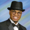 African-American man with glasses in hat and tuxedo