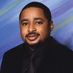 African-American man with beard and mustache in suit and tie
