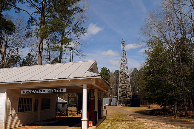 Building labeled "Education Center" with covered drive through entrance and oil derrick