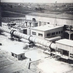 Multistory industrial buildings with smokestack and pipe connecting outbuildings