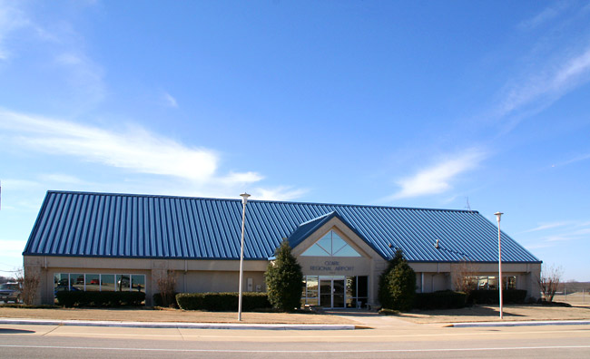 building with metal roof with sign "Ozark Regional Airport"