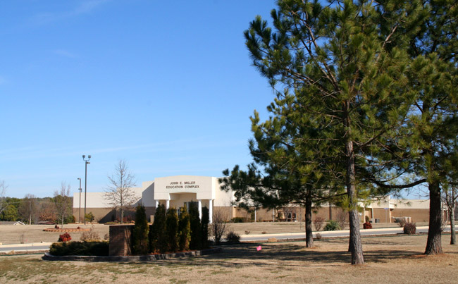 building behind trees "John E. Miller Education Complex"