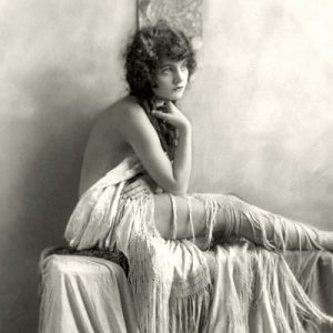 white woman poses draped in fringed shawl
