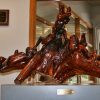 richly stained wooden sculpture on gray display stand