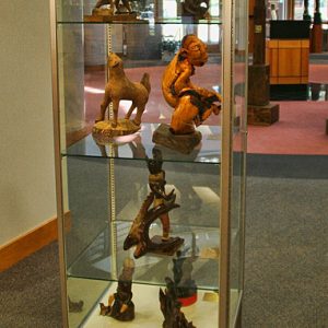glass display case with various sculptures depicting humans and animals