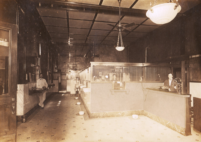 Bank interior with teller, telephone service operator, and other employee.