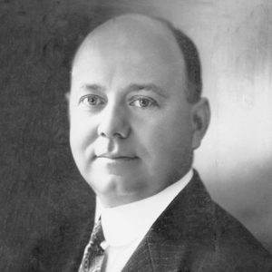 Bald clean-shaven white man in suit jacket and tie