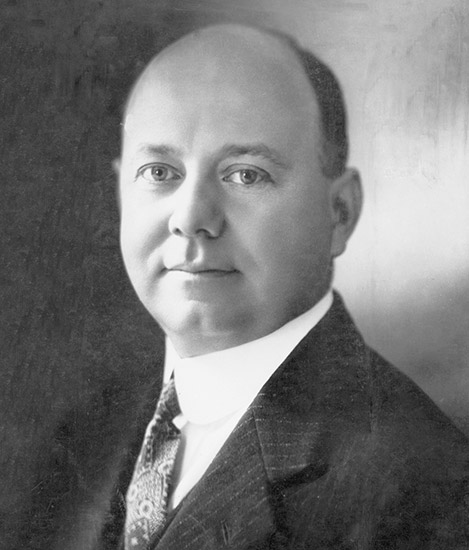 Bald clean-shaven white man in suit jacket and tie
