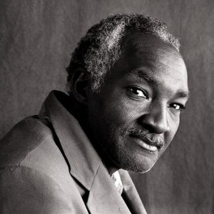 African-American man with graying hair and mustache in suit jacket